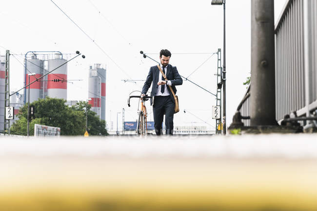 Бизнесмен с велосипедом ждет на платформе — стоковое фото
