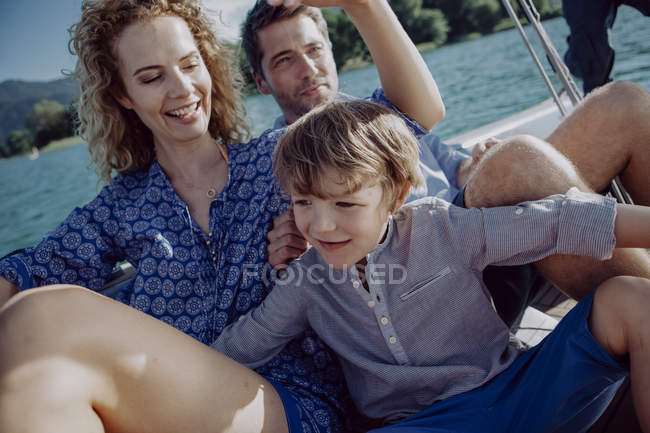 Счастливая семья отдыхает на парусной лодке — стоковое фото