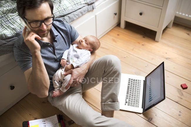 Father with his baby daughter working from home — Stock Photo