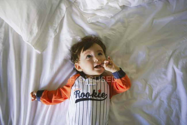 Retrato de bebé niña con mono acostado en la cama - foto de stock