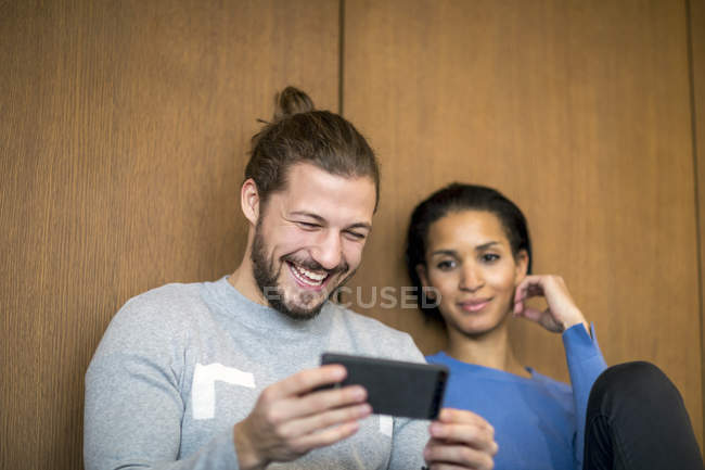 Portrait d'homme riant regardant le téléphone portable — Photo de stock