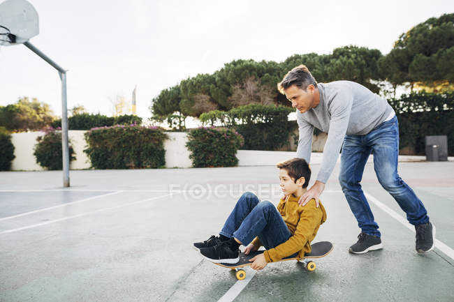 Батько допомоги сина їзда скейтборд — Stock Photo