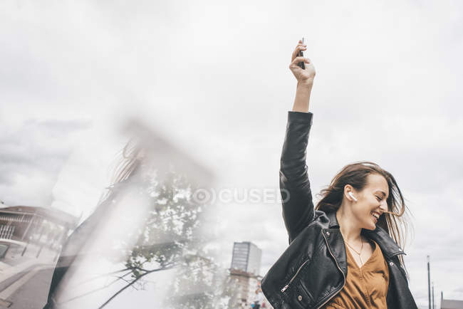 Mujer joven feliz con auriculares y teléfono celular - foto de stock