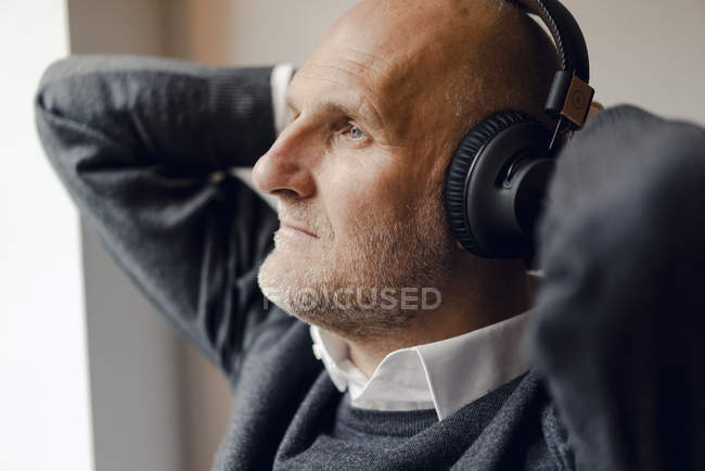 Homem sênior usando fones de ouvido, ouvindo música, retrato — Fotografia de Stock