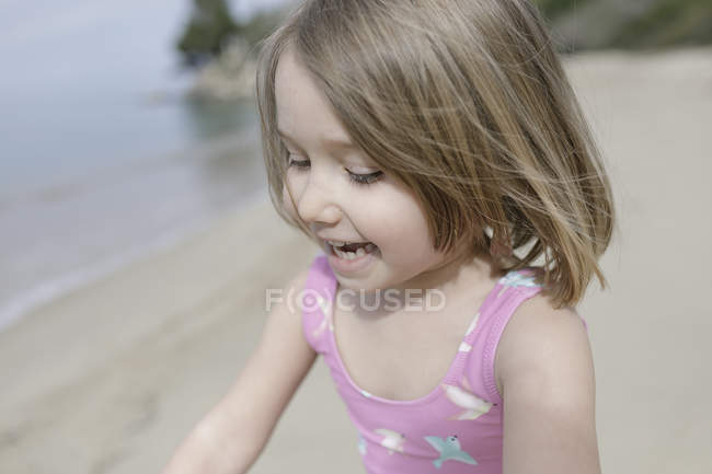 Portrait of happy little girl playing n the beach — Stock Photo