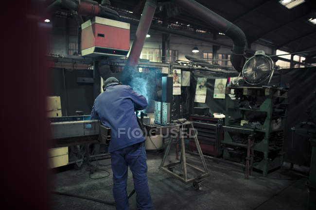 Welder welding metal in a factory — Stock Photo