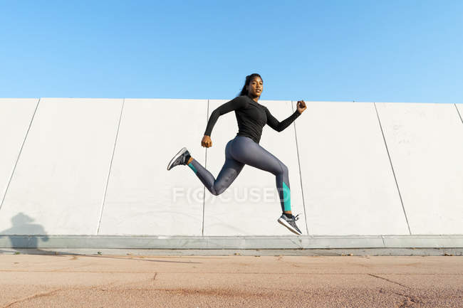 Молодая женщина прыгает во время тренировки на открытом воздухе — стоковое фото