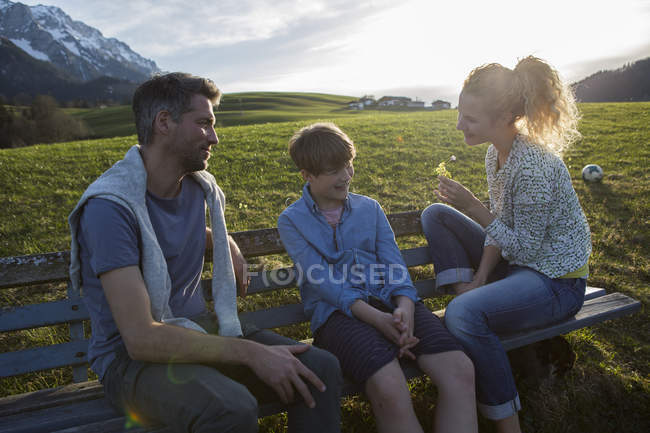 Австрия, Тироль, Вальхзее, счастливая семья отдыхает на скамье в горах — стоковое фото