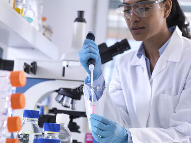 Genetische Forschung, Wissenschaftlerin pipettiert DNA- oder chemische Probe in ein Eppendorfer Fläschchen, Analyse im Labor — Stockfoto