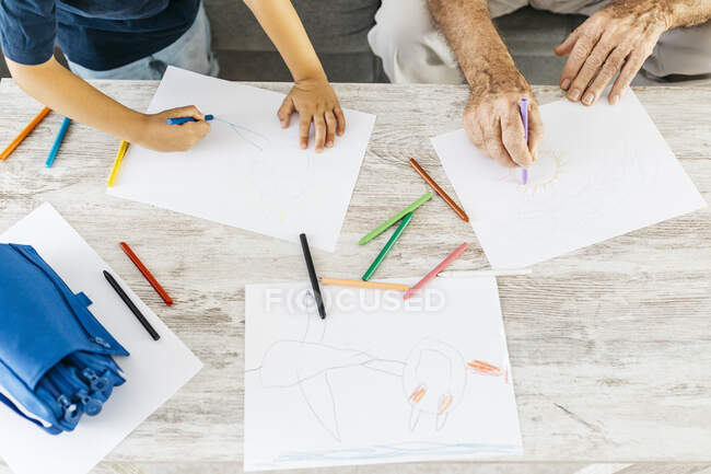 Dessin de grand-père et petit-fils avec crayons de couleur à la maison, vue partielle — Photo de stock