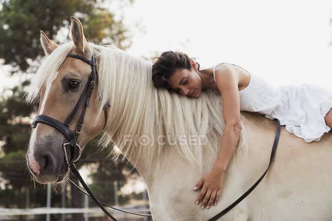 Donna rilassante a cavallo bianco all'aperto — Foto stock