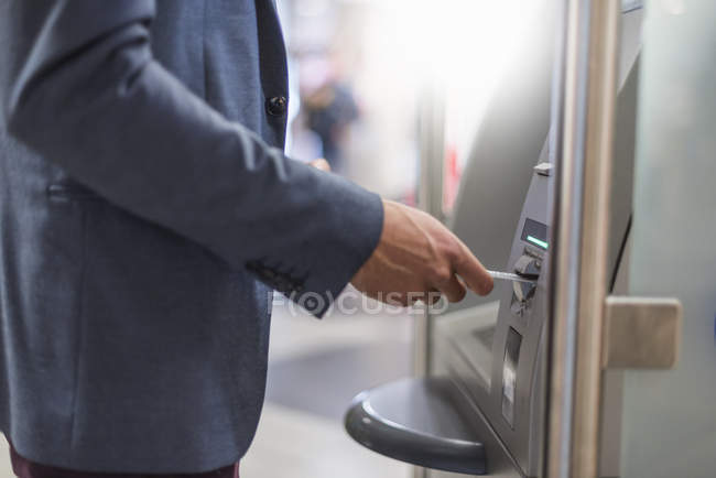 Close-up of businessman withdrawing money at an ATM — Stock Photo