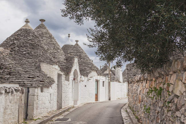 Italia, Apulia, Alberobello, vista al callejón con Trulli típico - foto de stock