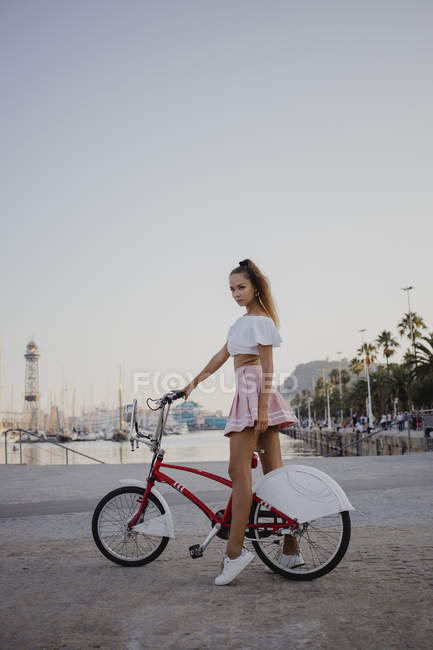 Fashionable young woman exploring Barcelona with bicycle — Stock Photo