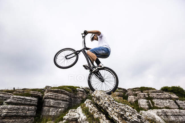 Motociclista acrobático en moto de trial - foto de stock