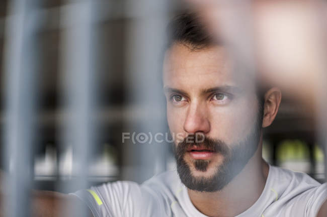 Porträt eines selbstbewussten Athleten hinter Gittern — Stockfoto