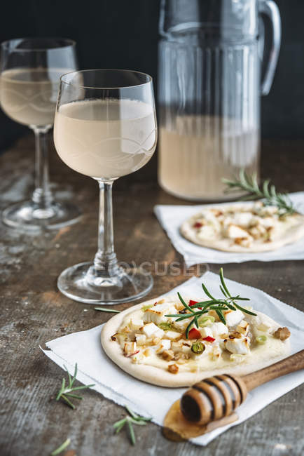 Tarte Flambee con mela, formaggio di capra, cipollotti, rosmarino e noci e Federweisser — Foto stock
