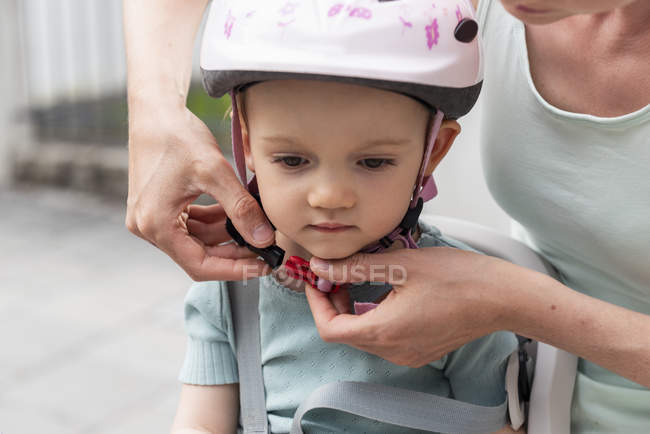 Mãe e filha, filha usando capacete, sentado no assento das crianças — Fotografia de Stock