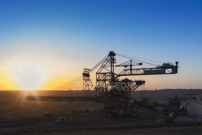 Alemanha, Renânia do Norte-Vestefália, Juechen, Garzweiler mina de superfície, empilhador durante a reparação ao pôr do sol — Fotografia de Stock
