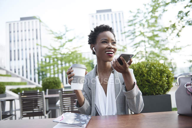 Retrato de mulher de negócios sorridente ao telefone no café da calçada — Fotografia de Stock