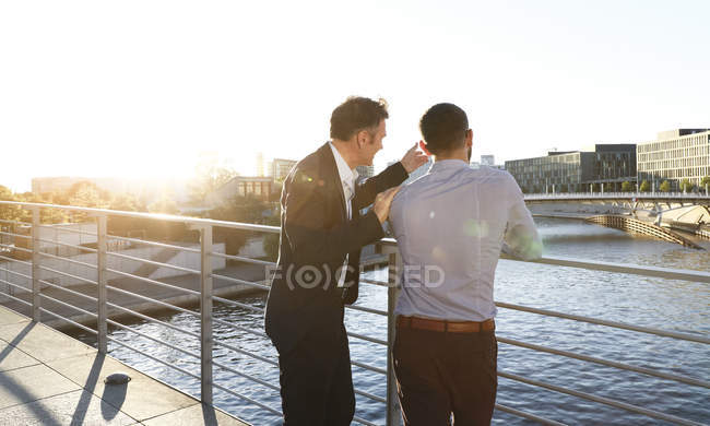 Two businessmen discussing on a bridge in city — Stock Photo