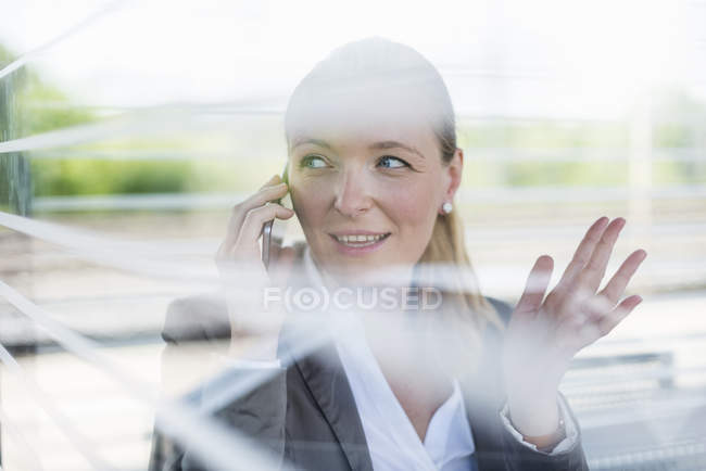 Портрет зрілої бізнес-леді по телефону, що чекає на платформі — стокове фото