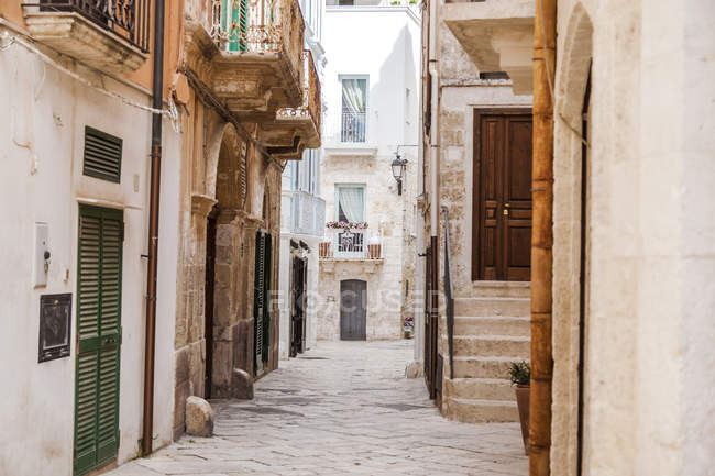 Italia, Puglia, Polognano a Mare, callejón estrecho en el casco antiguo histórico - foto de stock