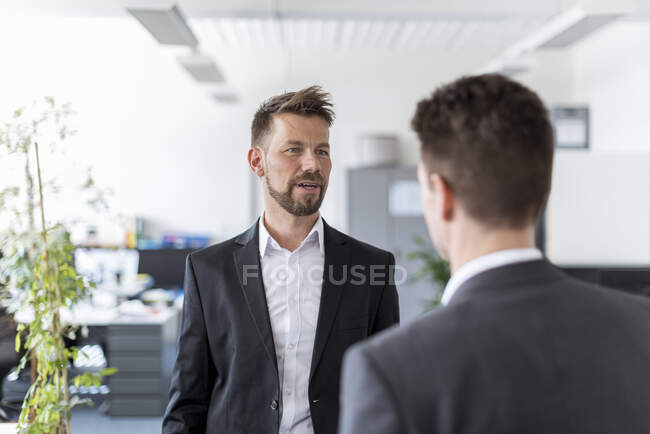 Два бізнесмени, що стоять на посаді, обговорюють рішення — стокове фото