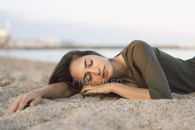 Красива жінка, відпочиваючи на пляжі на заході сонця, портрет — стокове фото