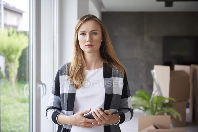 Portrait of serious woman moving into new flat — Stock Photo