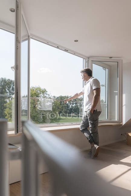 Maturo uomo in piedi a finestra in camera vuota — Foto stock
