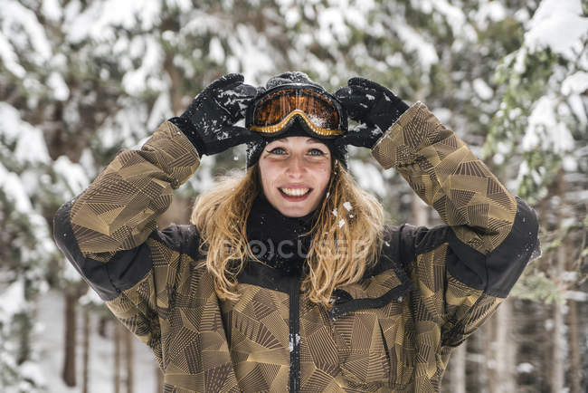 Ritratto di giovane donna felice in abbigliamento da sci nella foresta invernale — Foto stock