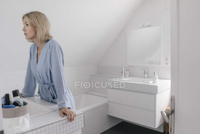 Зрелая женщина очищает плитку в ванной комнате | Бесплатно Фото