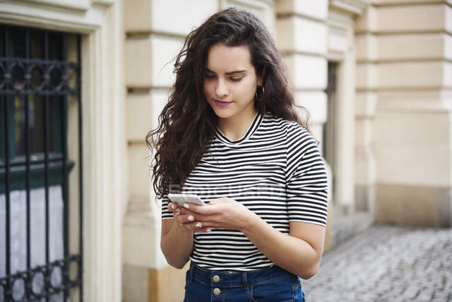Young woman using cell phone in the city — Stock Photo