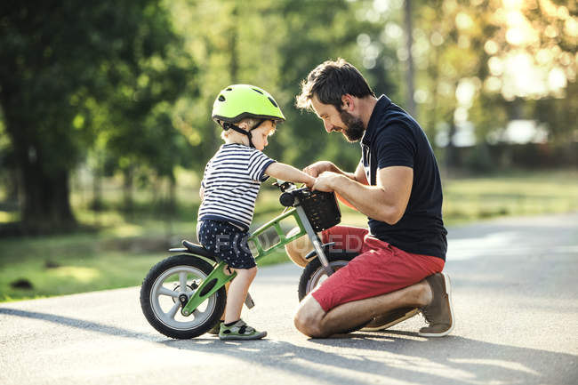 Pai apoiando pequeno filho de bicicleta — Fotografia de Stock