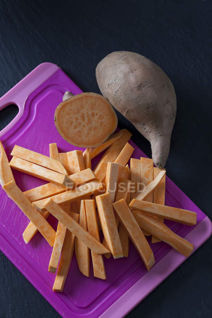 Cortado en rodajas y batata entera - foto de stock