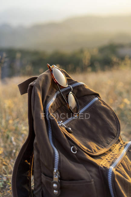 Закрыть солнцезащитные очки и рюкзак в горах — стоковое фото