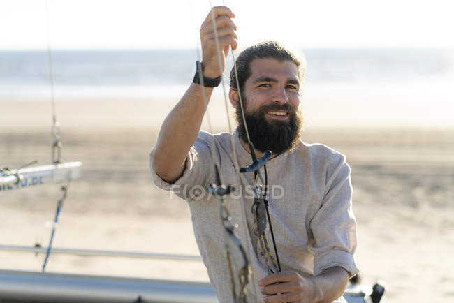 Молодий чоловік, сидячи на човні і посміхаючись — стокове фото