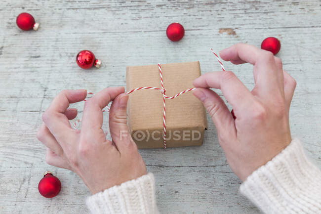 Las manos de la mujer envolviendo regalo de Navidad - foto de stock