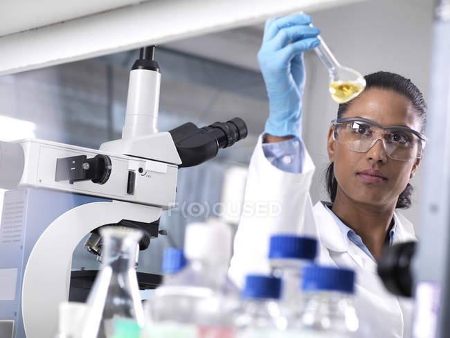 Biotechnology Research, científica femenina que mezcla una fórmula química - foto de stock