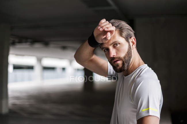Retrato de atleta en garaje con sudadera - foto de stock