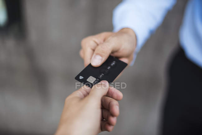 Gros plan de l'homme d'affaires qui remet sa carte de crédit — Photo de stock