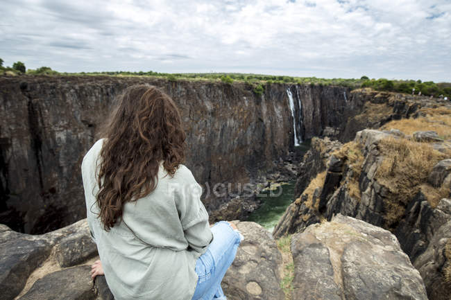 Zimbabwe, woman on rocks watching Victoria Falls — Stock Photo