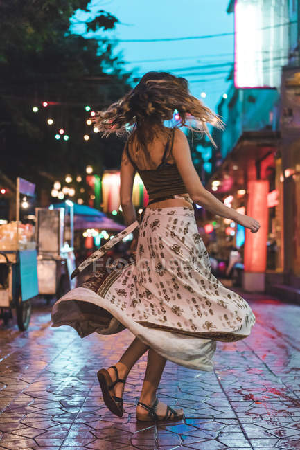 Thailand, Bangkok, young woman in the city dancing on the street at night — Stock Photo