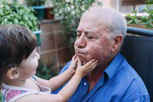 Nonno e bambina giocano insieme sulla terrazza — Foto stock