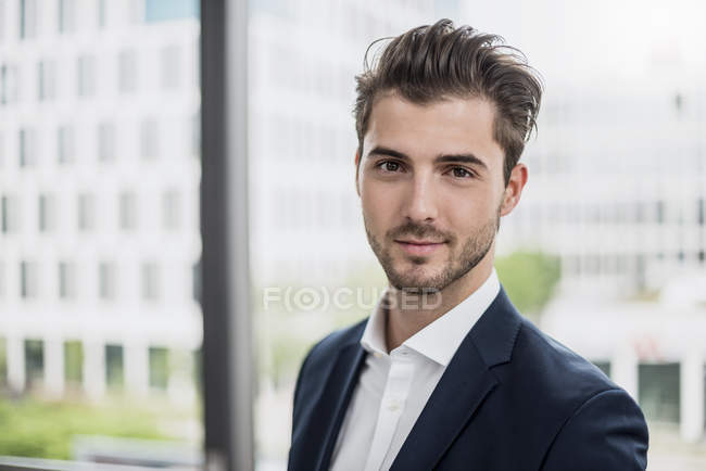 Ritratto di giovane uomo d'affari sicuro alla finestra — Foto stock