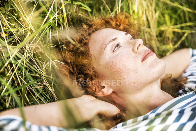 Primo piano della giovane donna che si rilassa sul prato verde — Foto stock