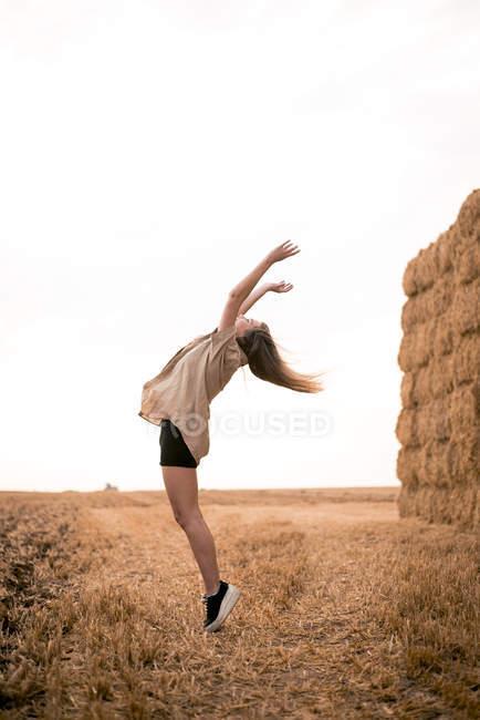 Felice giovane donna che salta nel campo — Foto stock