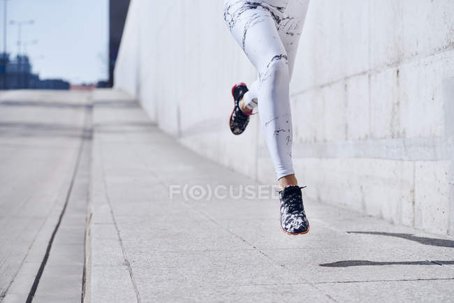 Femme coureuse pendant l'entraînement urbain — Photo de stock