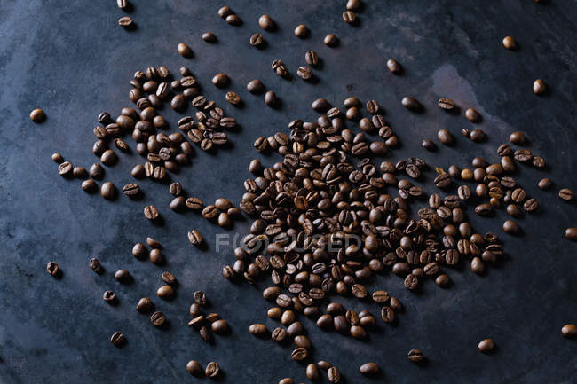 Grãos de café recém-torrados em fundo escuro — Fotografia de Stock